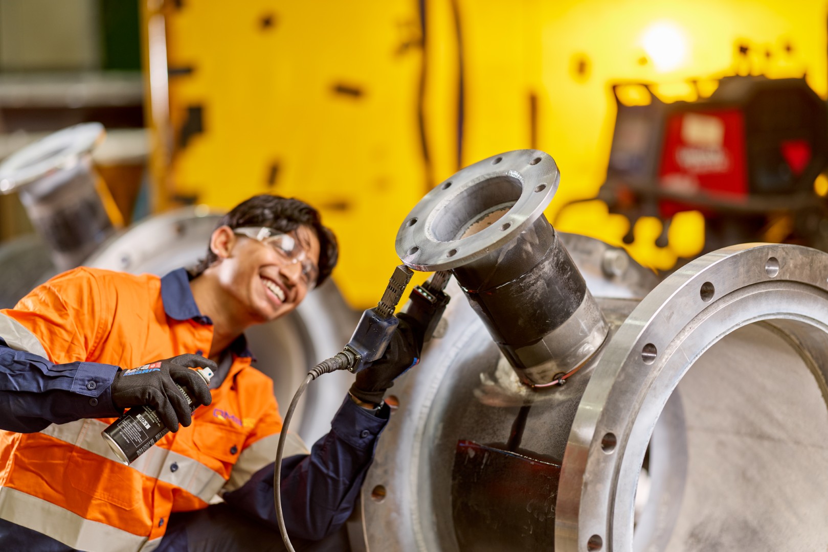 QMS technician performing magnetic particle inspection on site